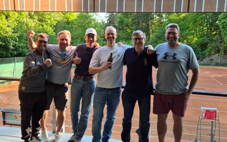 Gruppe von Männern auf einem Tennisplatz im Freien, sommerliche Stimmung