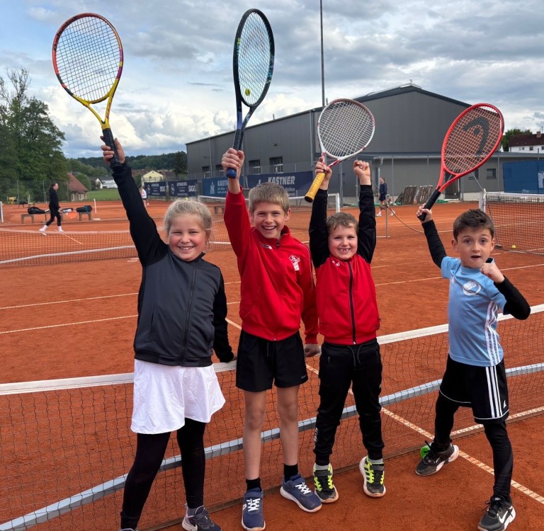 Kinder spielen Tennis auf einem Kleinfeld-Tennisplatz
