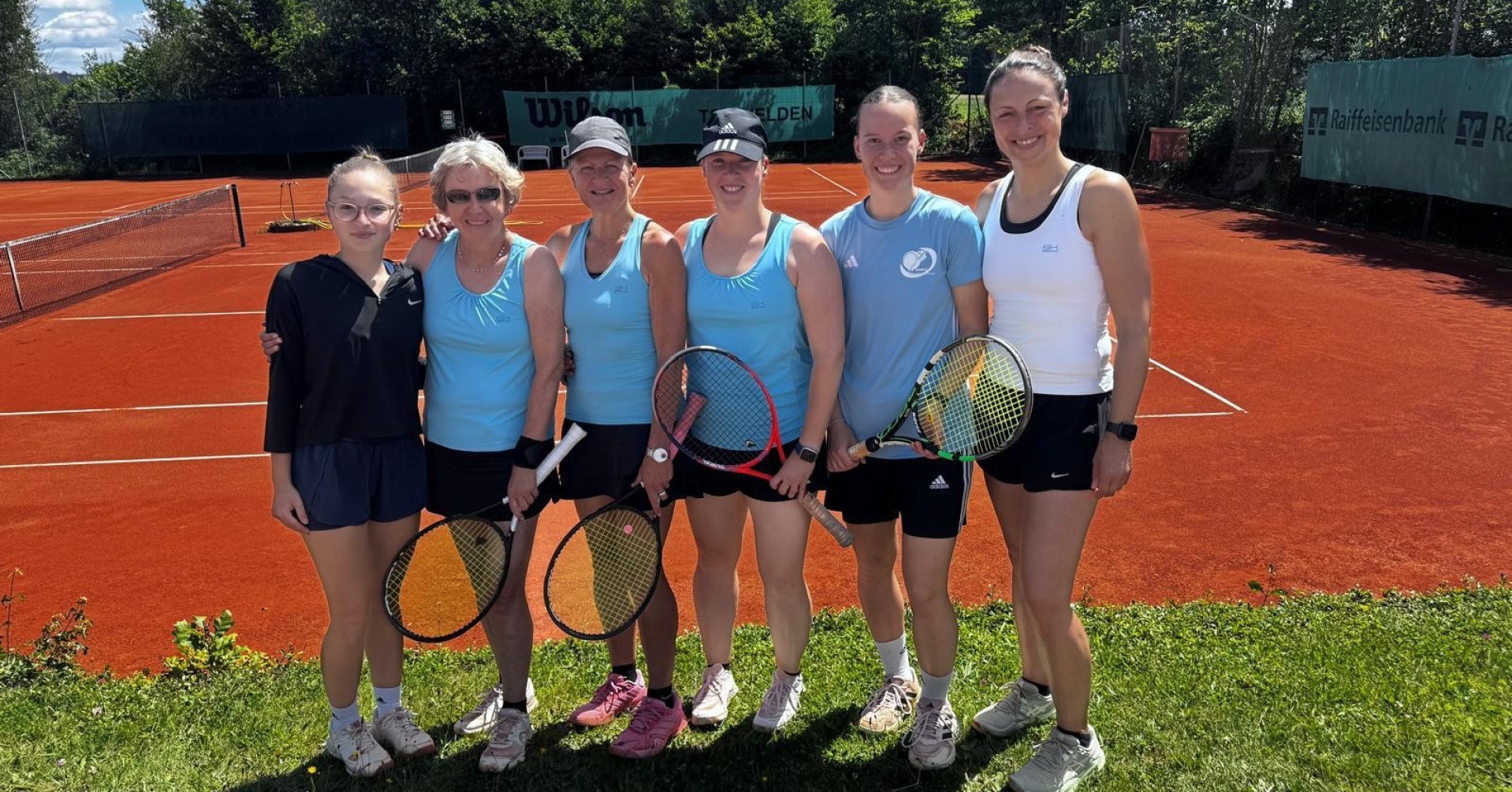 Damen Tennis Mannschaft auf Sandplatz bei sonnigem Wetter