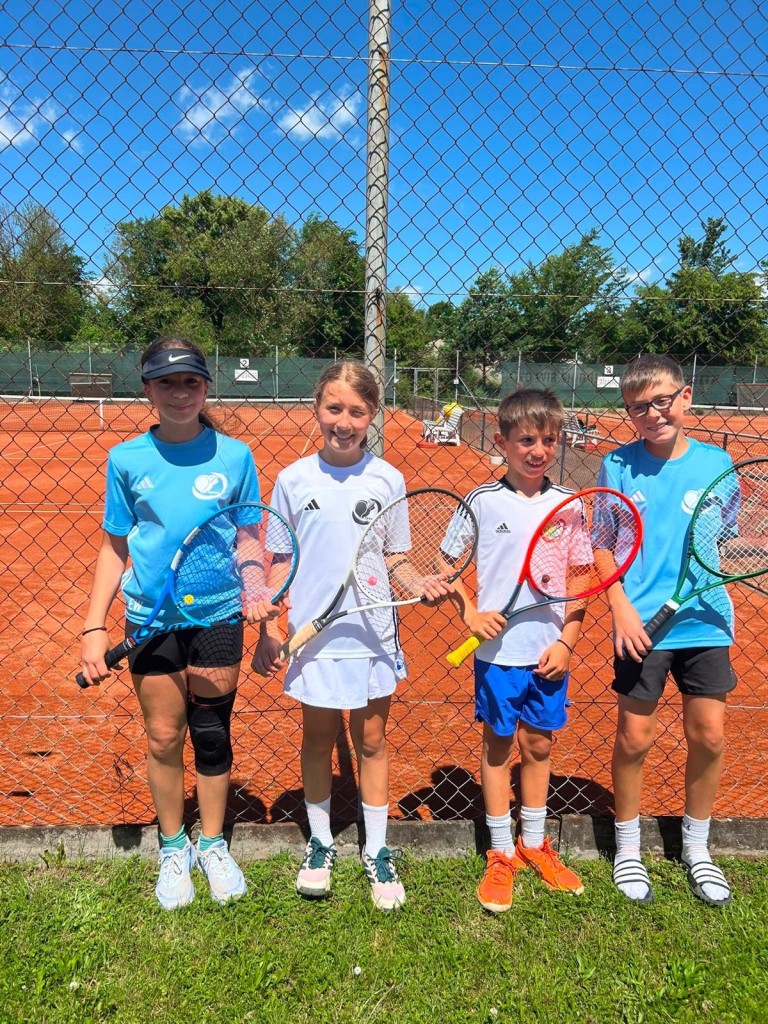 Bambini Tennisgruppe auf Sandplatz mit Tennisschlägern