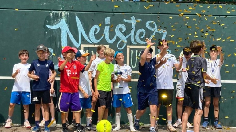 Kinder bei der Siegerehrung eines Fußballturniers mit Pokal Kinder feiern den Sieg bei einem Fußballturnier mit Pokal und Konfetti.