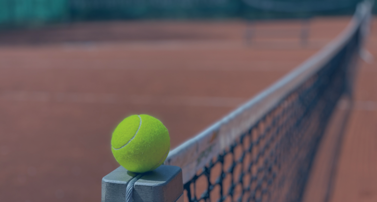 Tennisball auf Netz auf Sandplatz – Symbolbild für die Montagsdamen-Gruppe im Tennisverein