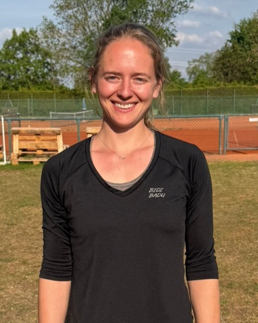 Frau auf Tennisplatz mit schwarzem Bidi Badu Shirt, lächelnd in die Kamera, aufgenommen am 01.07.2026