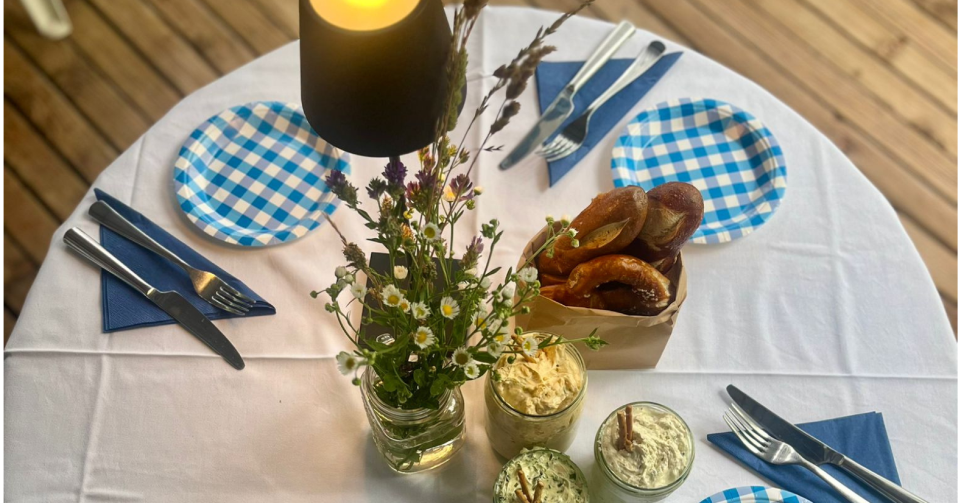 Bayerische Brotzeit mit Brezeln, Aufstrichen und Wildblumen als Tischdekoration, aufgenommen für die Startseite von TC WB