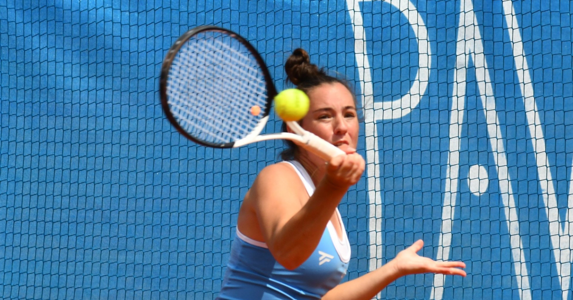Anne Knüttel 2025 Tennisspielerin in blauer Sportbekleidung beim Vorhand-Schlag vor blauem Hintergrund