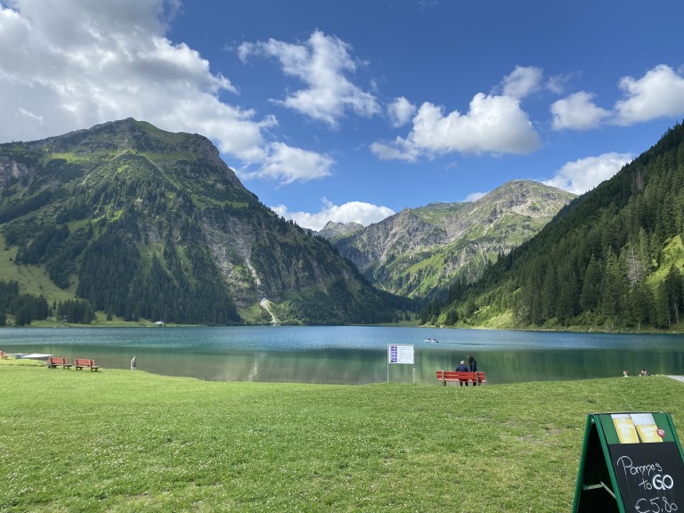 Alpenpanorama mit kristallklarem Bergsee und bewölktem Himmel