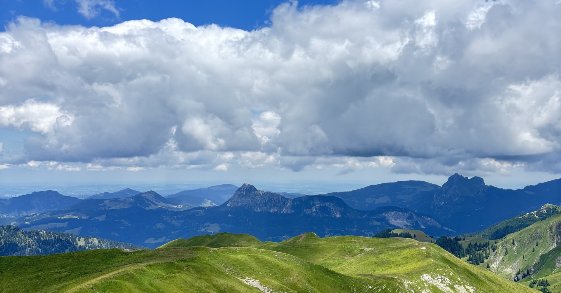 Alpine Berglandschaft mit grünen Hügeln und bewölktem Himmel