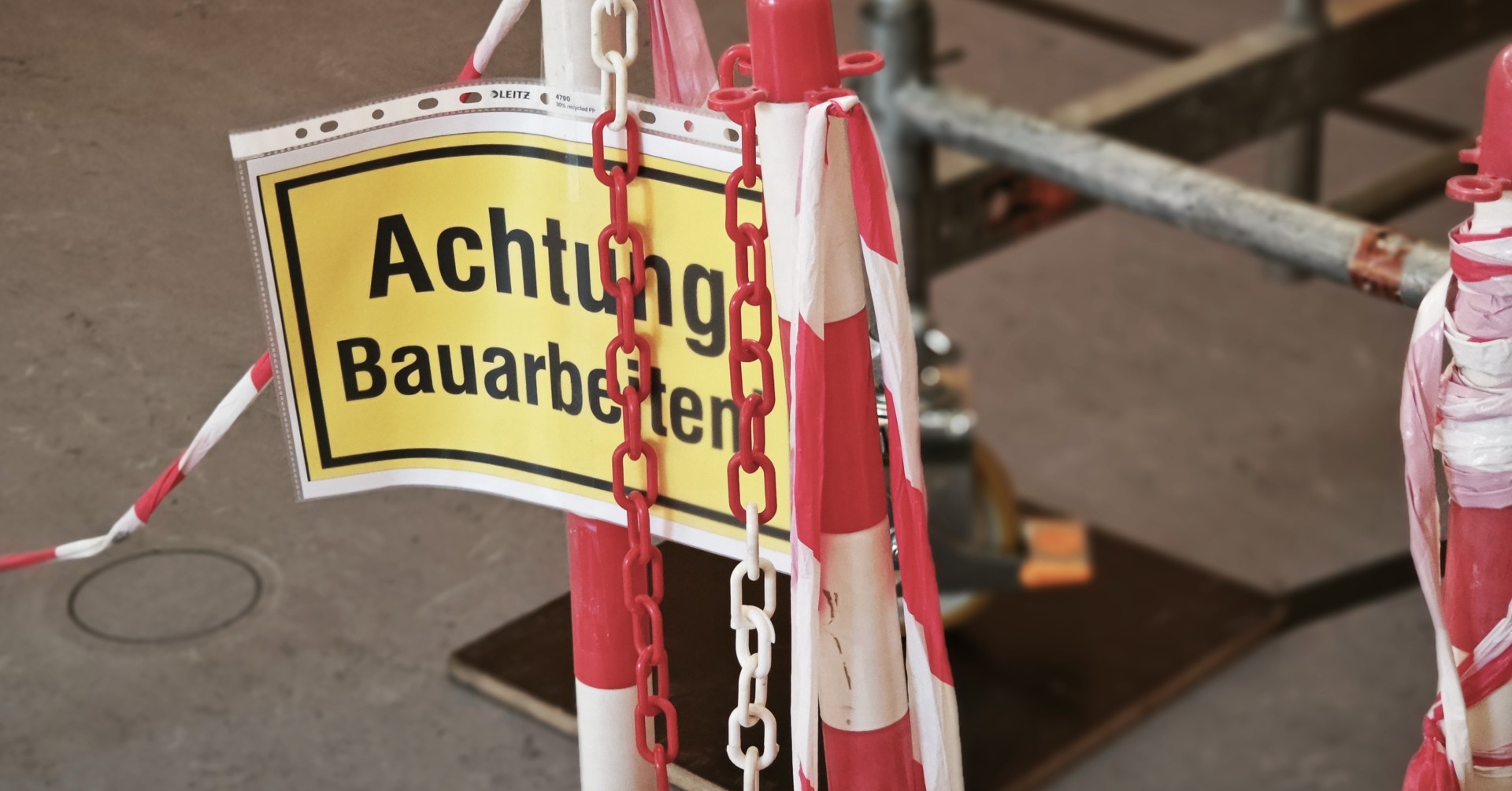 Warnschild Achtung Bauarbeiten mit Absperrung und Ketten auf einer Baustelle