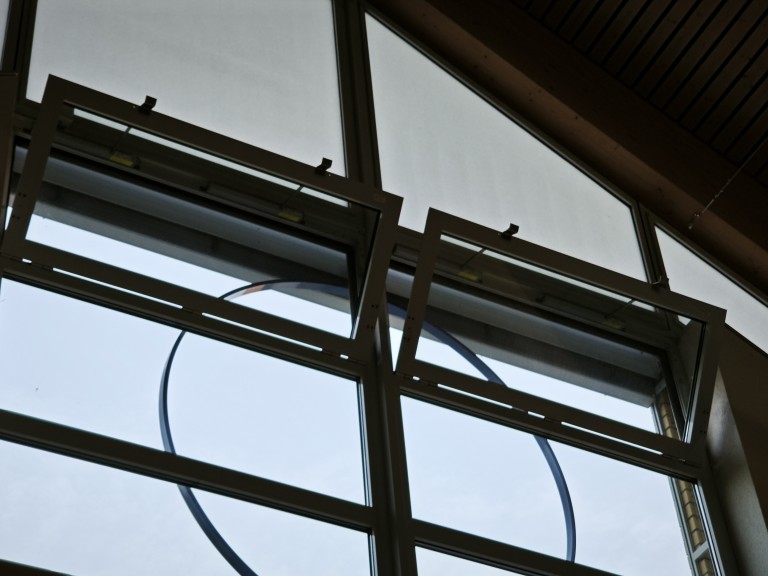 Geöffnete moderne Fensterfront mit Glas und Metallrahmen in einem Gebäude, Blick nach draußen
