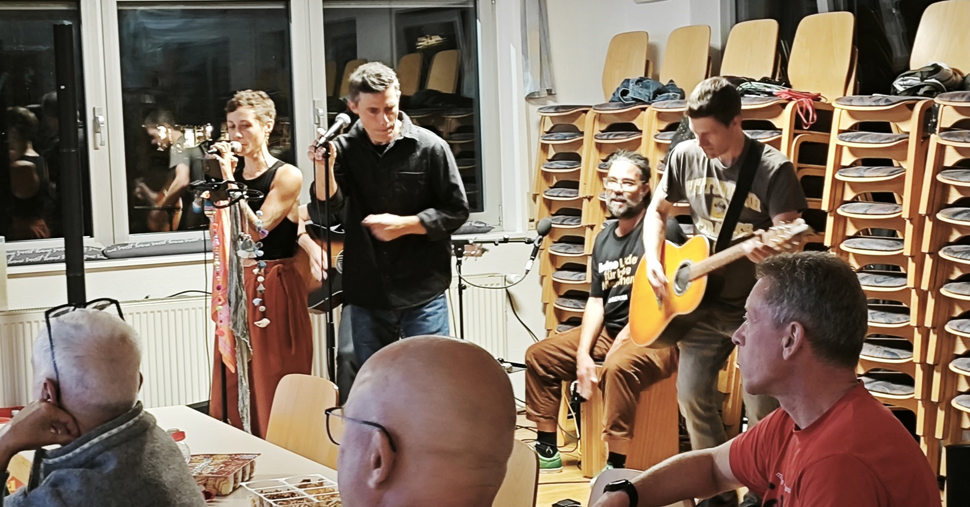 Live Musik-Auftritt bei einer Veranstaltung am 24. September 2025 mit Band und Publikum in einem Gemeinschaftsraum