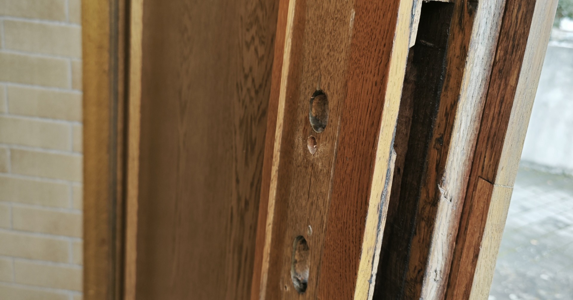 Nahaufnahme einer aufgebrochenen Holztür mit beschädigtem Türrahmen