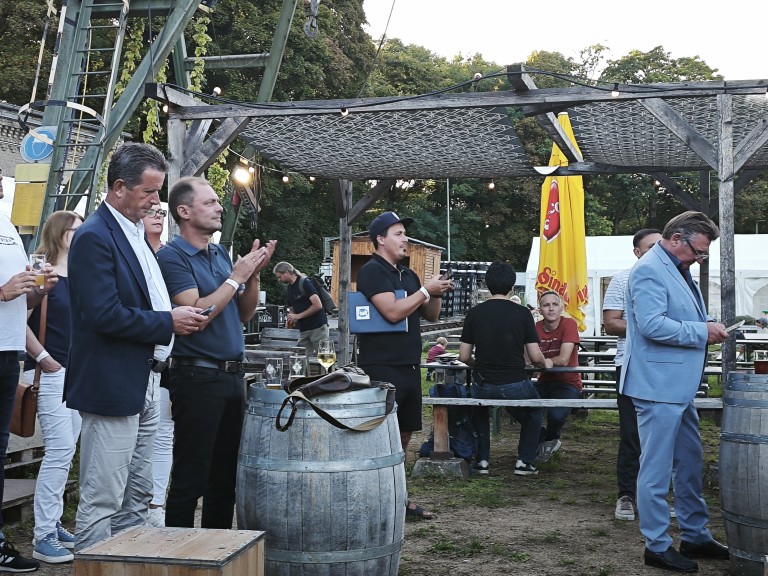 Menschen bei einer Outdoor-Veranstaltung mit Wein und geselligem Beisammensein im Spätsommer