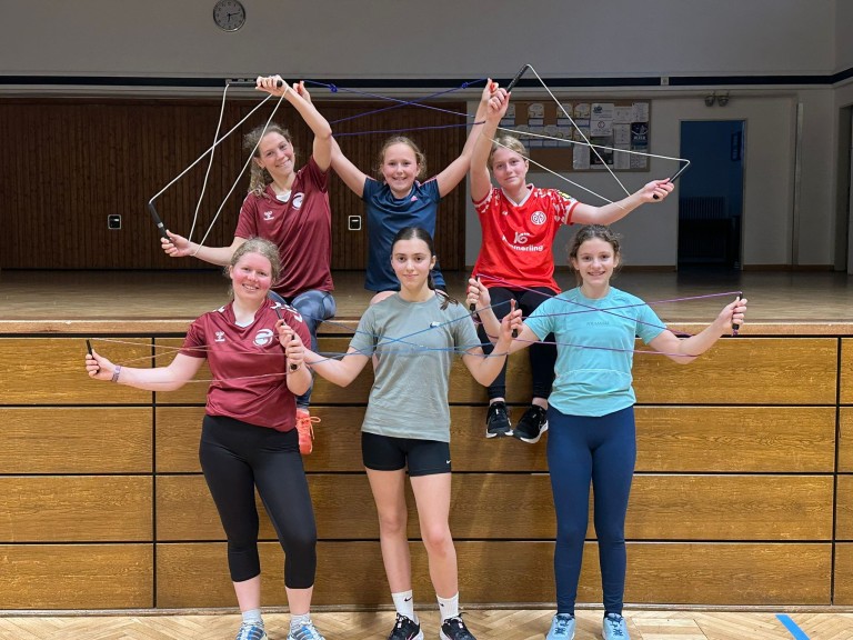 Jugendliche beim Seilspringen in der Turnhalle – Sportgruppe Gruppe von Jugendlichen beim Seilspringen in einer Turnhalle