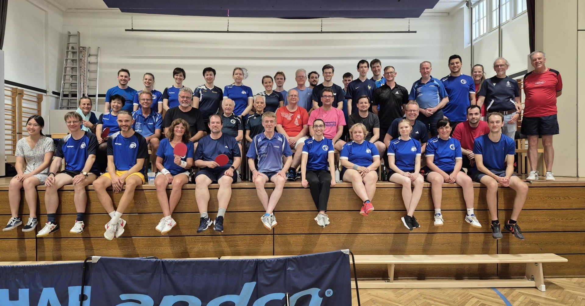 Gruppenfoto Tischtennisspieler in Sporthalle mit Andro-Bande Gruppenfoto von Tischtennisspielern in einer Sporthalle mit Andro-Bande