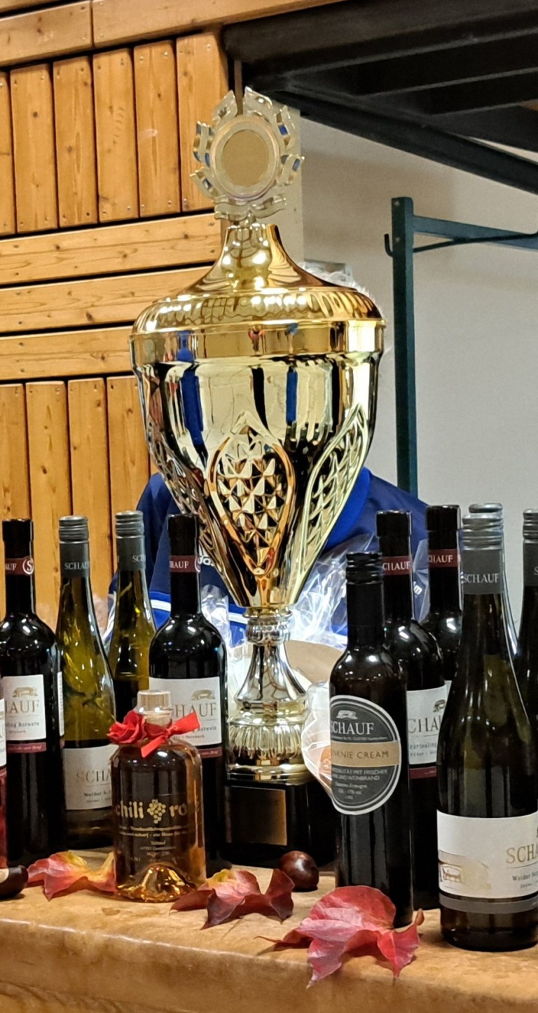 Großer goldener Pokal mit mehreren Flaschen Schauf Wein als Gewinn bei einem Wettbewerb