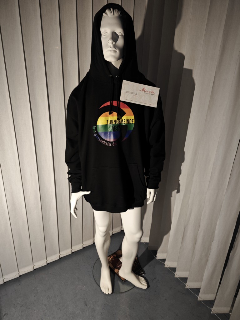 Schaufensterpuppe mit schwarzem Hoodie von Marla Mode und Manufaktur, Motiv Turngemeinde 1861 mit Regenbogen-Logo