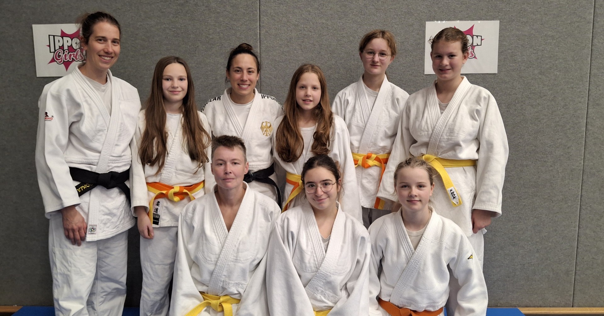 Judo-Gruppe mit Jugendlichen im weißen Judoanzug und farbigen Gürteln