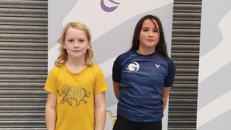 Teilnehmer beim Mincup 3 vor dem Event-Logo, zwei Kinder in Sportkleidung