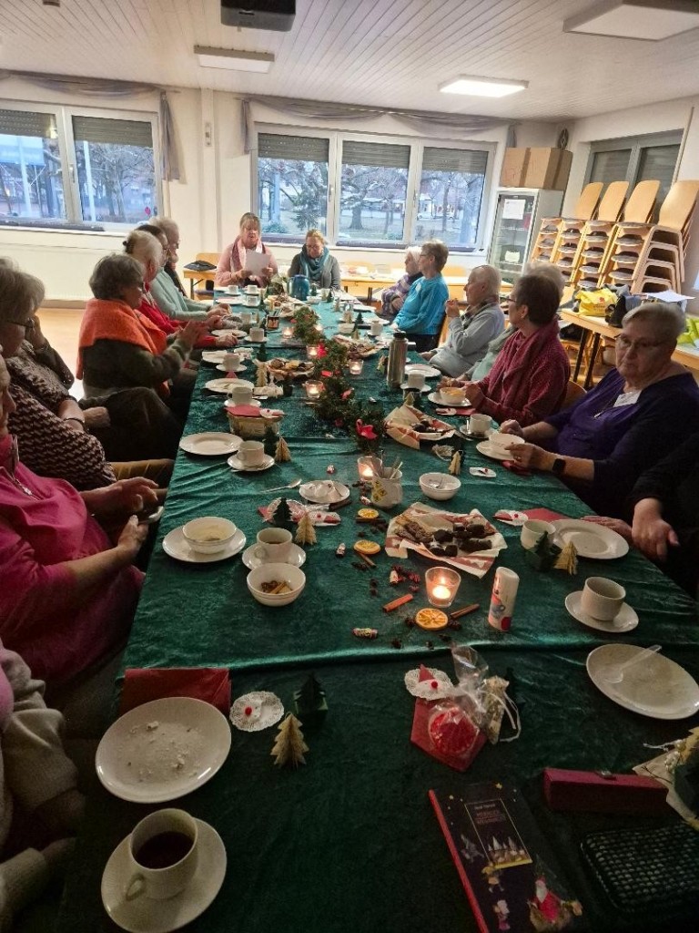 Gemütliche Adventsfeier mit festlich gedecktem Tisch, Kerzen, Gebäck und mehreren Personen in geselliger Runde