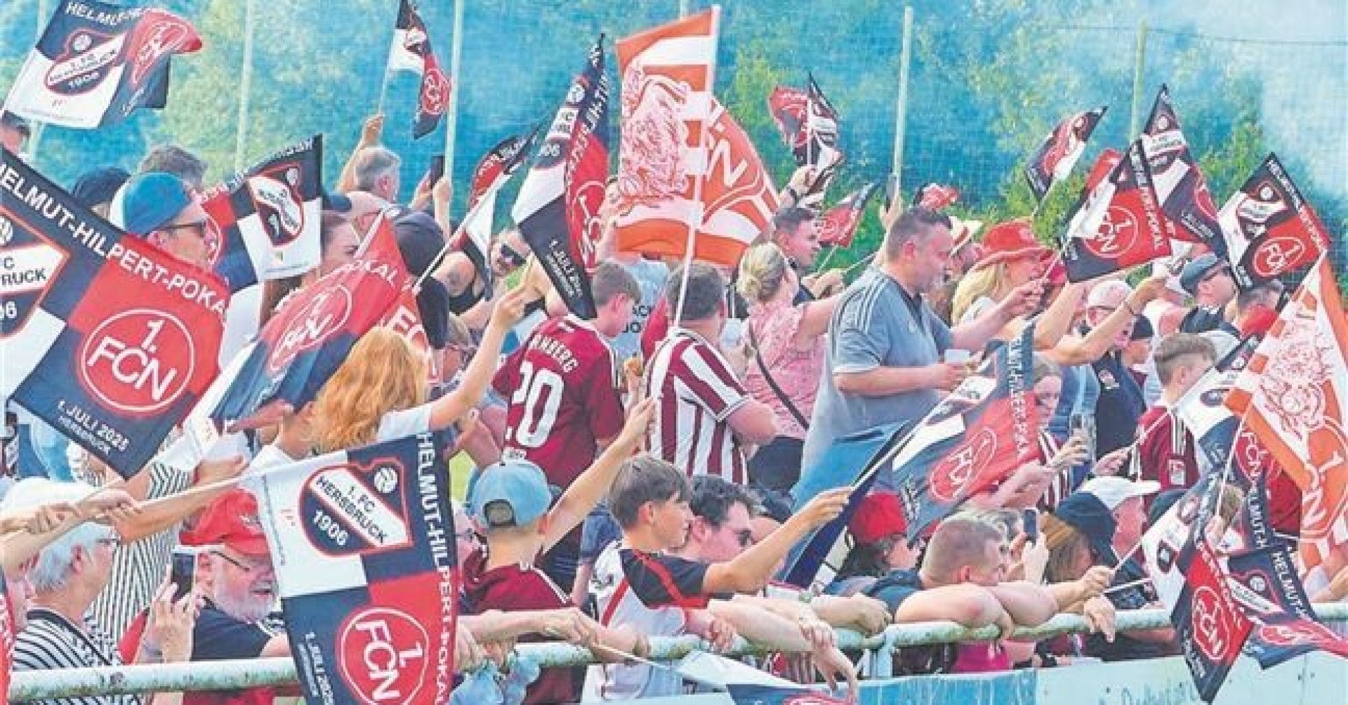 Fußballfans feiern im Stadion mit Vereinsfahnen Fußballfans jubeln im Stadion mit Fahnen und Trikots