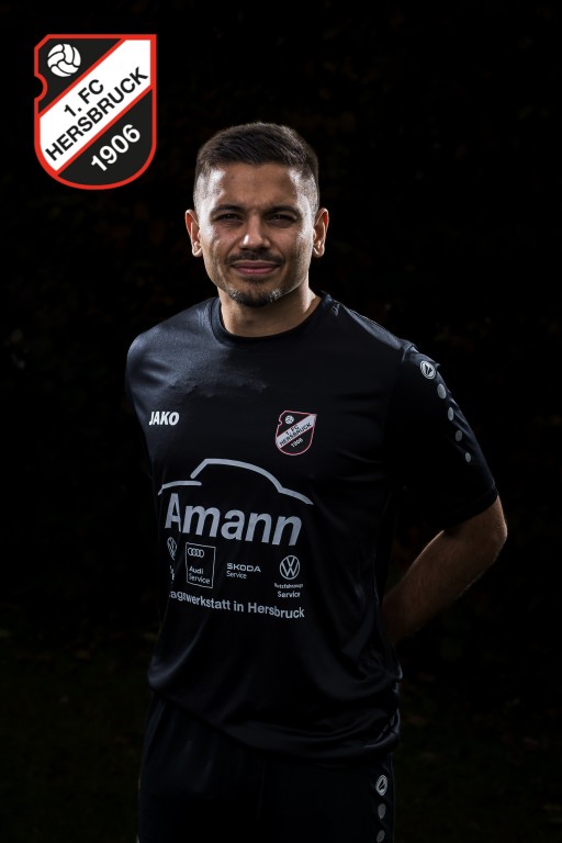 Fußballspieler des 1. FC Hersbruck 1906 im schwarzen Jako-Trikot mit Amann-Werbung