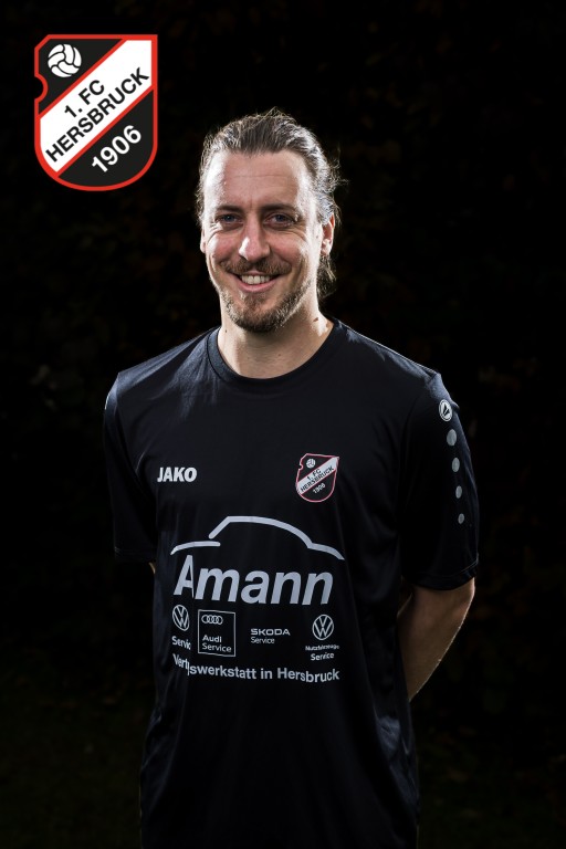 Fußballspieler des 1. FC Hersbruck 1906 im schwarzen JAKO-Trikot mit Amann-Werbung