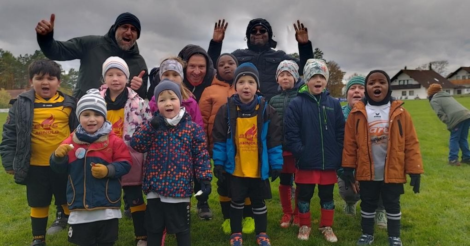 Kinderfußballmannschaft mit Trainern auf dem Fußballfeld im Herbst Kinderfußballmannschaft mit Trainern auf einem Fußballfeld im Herbst