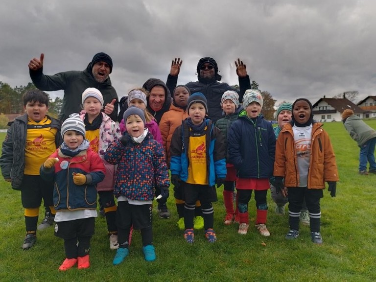 Kinderfußballmannschaft mit Trainern auf dem Fußballfeld im Herbst Kinderfußballmannschaft mit Trainern auf einem Fußballfeld im Herbst