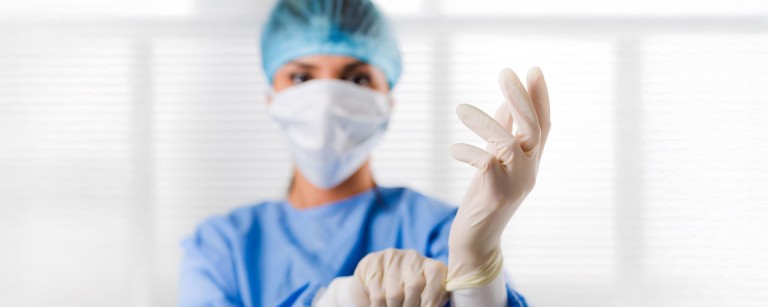 Prostata Hilfe Deutschland: Ärztin zieht sich Handschuhe an