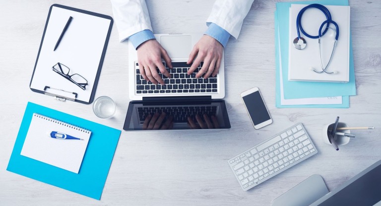Prostata Hilfe Deutschland: Arzt mit Laptop und Smartphone