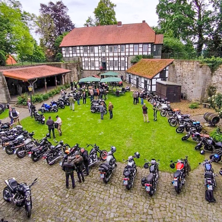 Der Gentleman's Ride 2026: Zum Abschluss trafen sich die Fahrer auf den Burggelände. Motorradtreffen beim PhD Gentleman's Ride vor einem Fachwerkhaus mit zahlreichen Teilnehmern und Motorrädern