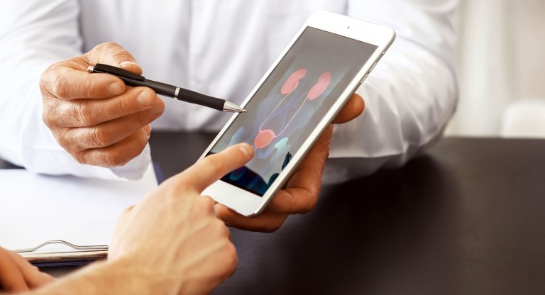 Prostatakrebs: Männer bereuen die Prostata-Op Prostata Hilfe Deutschland: Arzt mit Tablet im Gespräch mit Patient