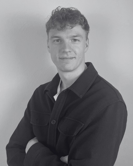 Porträt eines jungen Mannes in Schwarz-Weiß mit verschränkten Armen