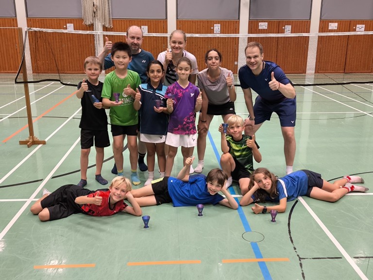 Gruppenfoto von Kindern und Trainer beim Badminton-Turnier in der Sporthalle Kindergruppe mit Trainer in einer Sporthalle beim Badminton-Turnier, Gruppenfoto mit Pokalen