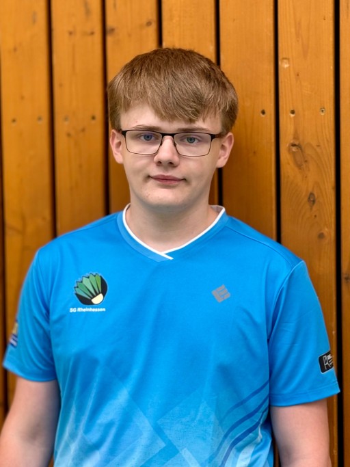 Mitglied der SG Rheinhessen im blauen Trikot vor Holzwand