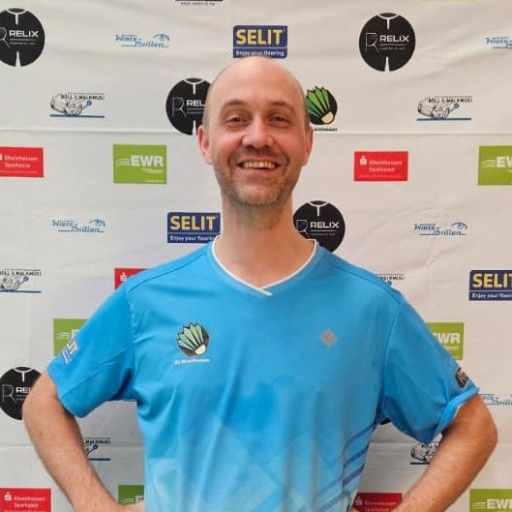 Daniel Wagner im blauen Sporttrikot vor Sponsorenwand beim Sportevent