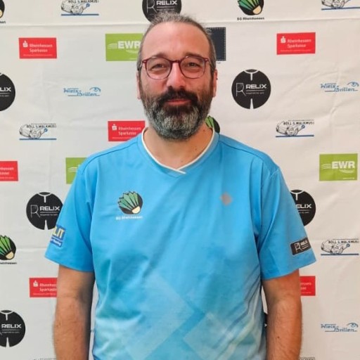 Michael Bothner im Trikot des SG Rheinhessen Badmintonvereins vor Sponsorenwand