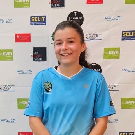 Emilia Winkler im blauen Trikot vor Sponsorenwand