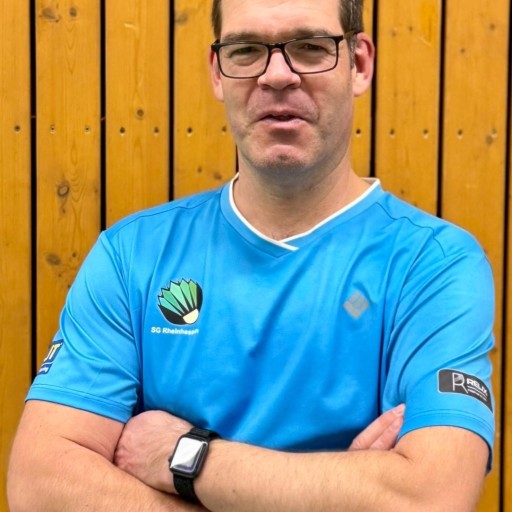 Andreas Brauns im SG Rheinhessen Trikot vor Holzwand