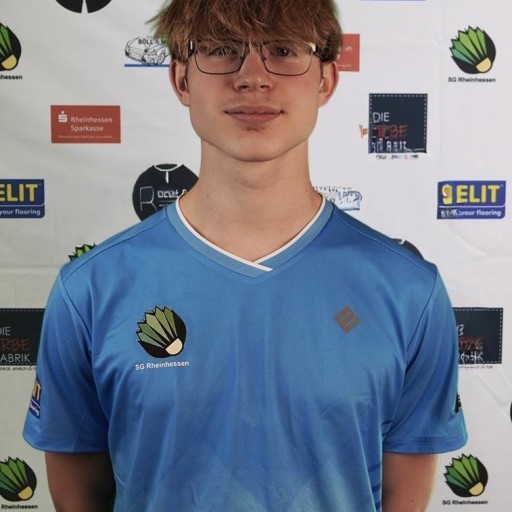 Spieler im blauen Trikot der SG Rheinhessen vor Sponsorenwand