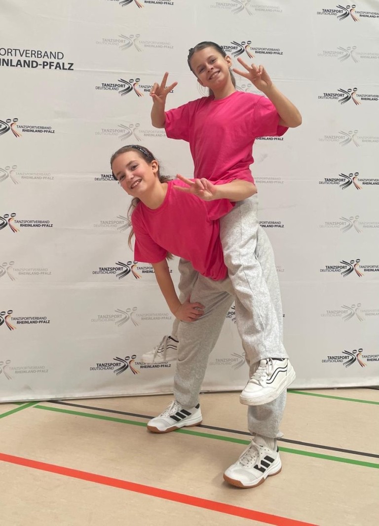 Zwei Tänzerinnen in pinken Shirts beim Tanzsportverband Rheinland-Pfalz Event