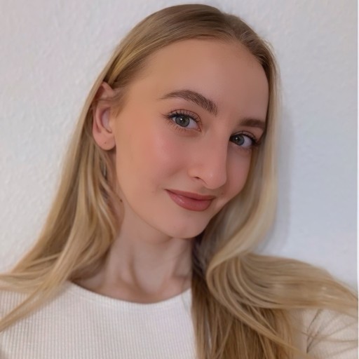 Domenica Erontschenko mit langen blonden Haaren vor weißer Wand