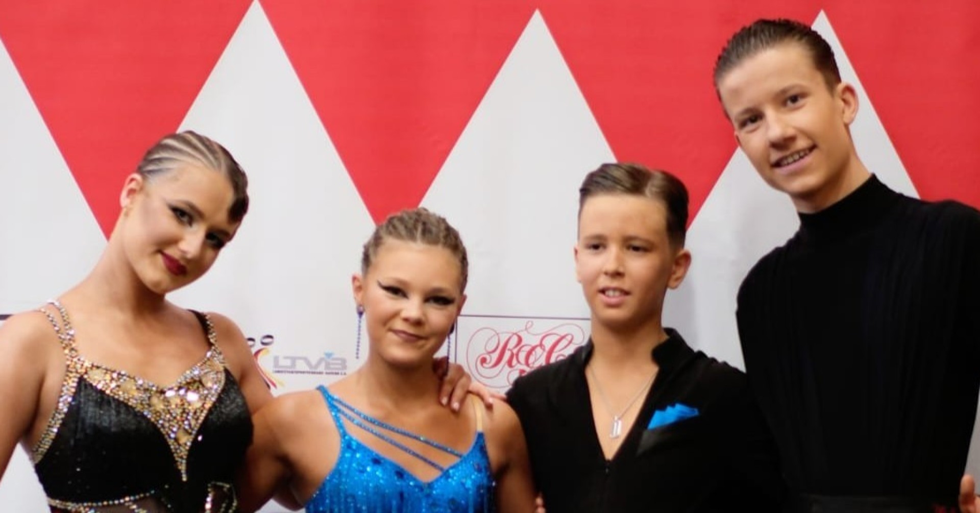 Tanzpaar in festlicher Kleidung bei einem Tanzwettbewerb vor rotem und weißem Hintergrund