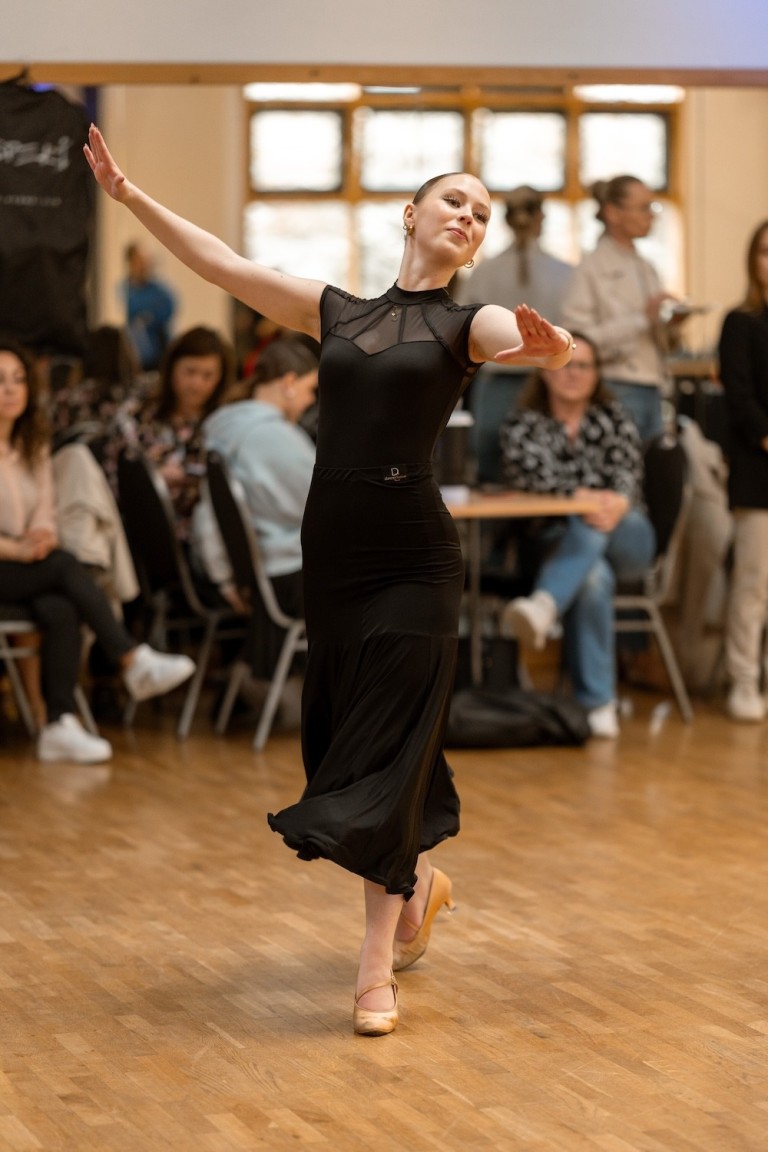 Hannah Schuelke tanzt elegant in einem schwarzen Kleid bei einem Tanzwettbewerb