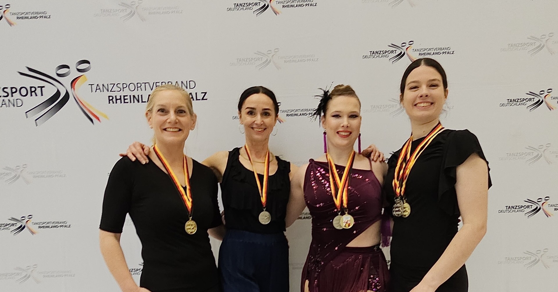TSZ Mittelrhein: Siegerinnen des Tanzturniers am 02.02.2025 beim Tanzsportverband Rheinland-Pfalz Siegerinnen des Tanzturniers beim TSZ Mittelrhein am 02.02.2025 mit Medaillen vor dem Banner des Tanzsportverbands Rheinland-Pfalz
