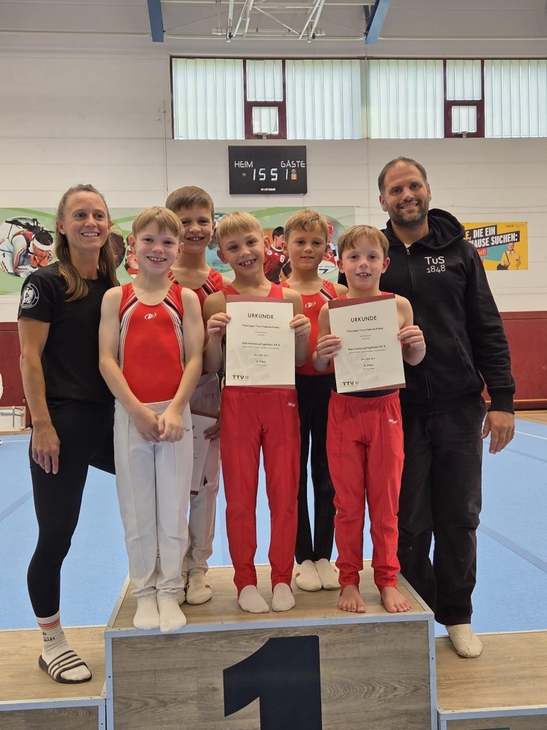 Junge Turner mit Urkunden und Trainern bei einem Turnwettkampf am 06.10.2025 in der Sporthalle