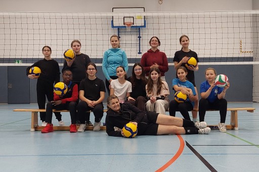 Volleyball Jugendgruppe mit Kerstin in der Sporthalle vor dem Volleyballnetz