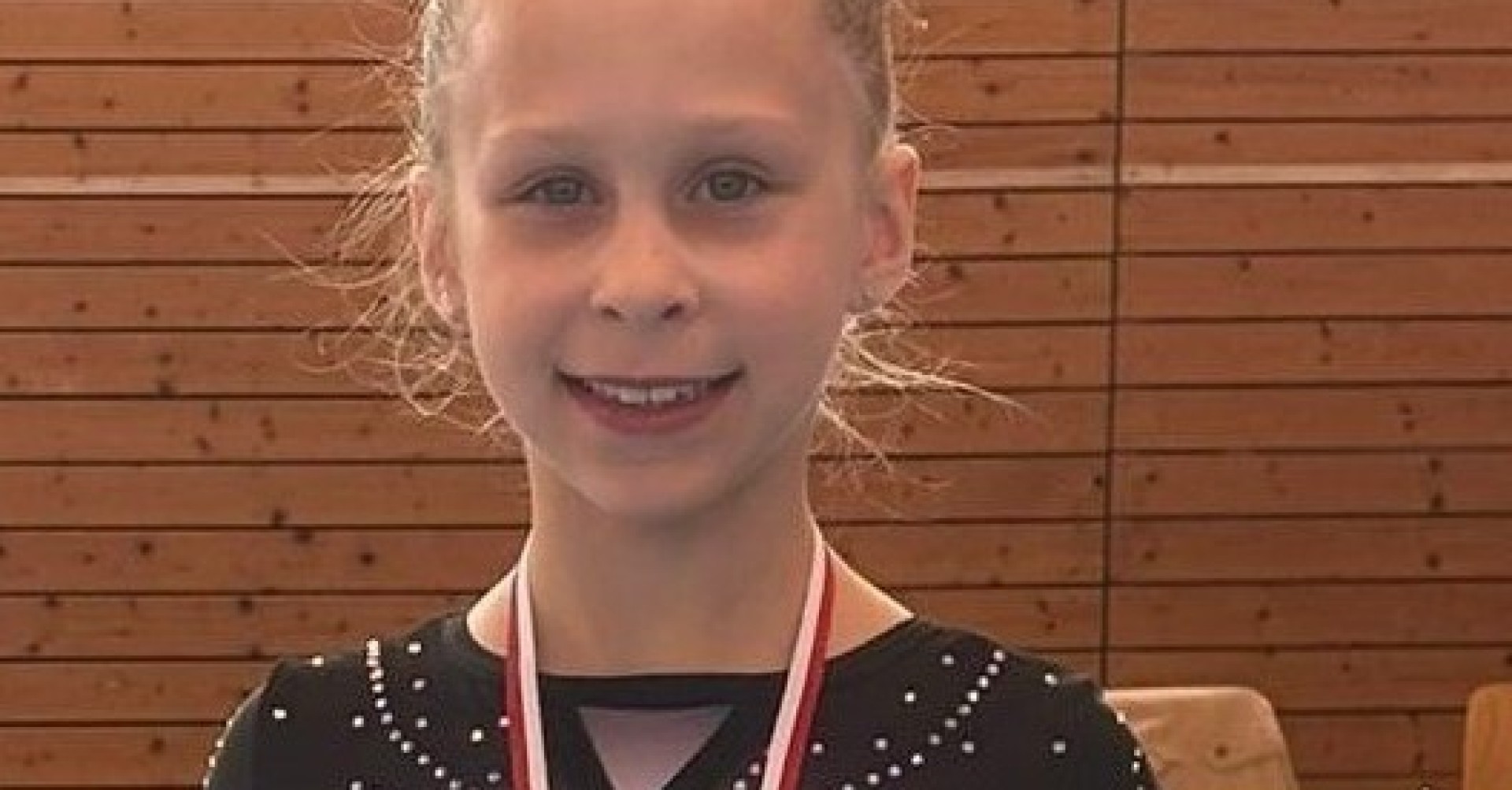 Emma R. mit Medaille bei einem Turnwettkampf am 26.3.