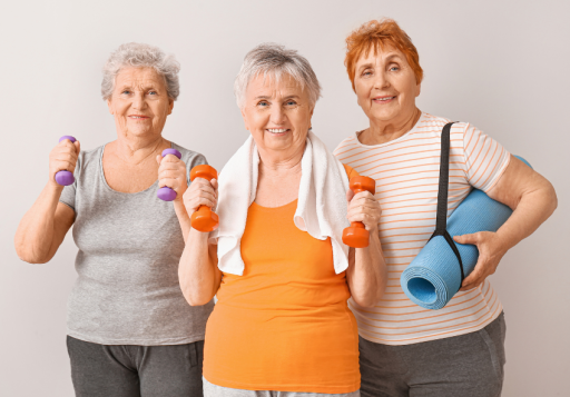 Drei aktive Seniorinnen mit Hanteln und Yogamatte vor einem hellen Hintergrund.