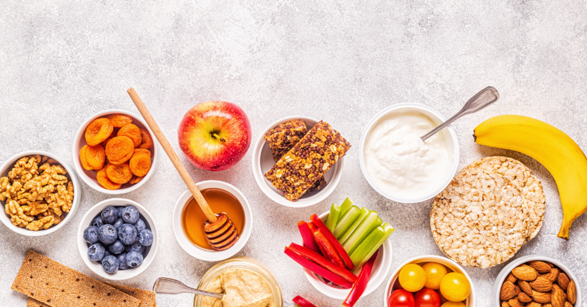 Gesunde Snack-Optionen mit Obst, Müsli und Gemüse Auswahl an gesunden Snacks mit Obst, Müsli und Gemüse auf hellem Hintergrund